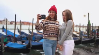 Teknelerle rıhtımda iki genç kadın telefonda fotoğraflandı ve fotoğrafa bakın