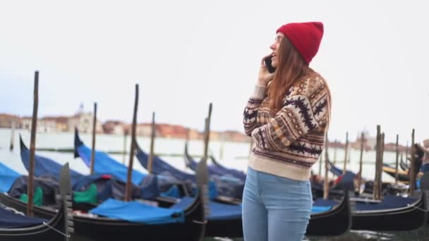 Mujer joven hablando por teléfono permaneciendo en el paseo marítimo — Vídeos de Stock