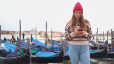 Genç çekici kadın rıhtımda kalan ve telefonuna bakar. Sonra gülümsüyor ve gülüyordu.