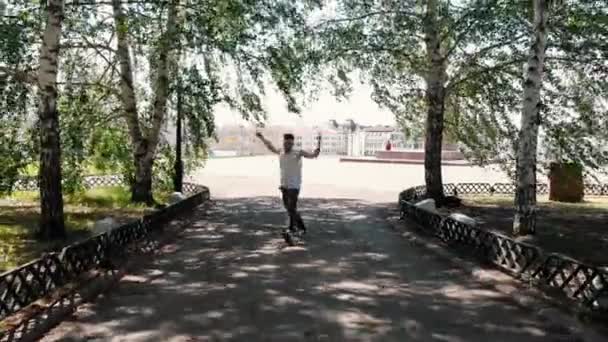 Un joven atlético tatuado bailando en la plaza al fondo de la ciudad — Vídeos de Stock