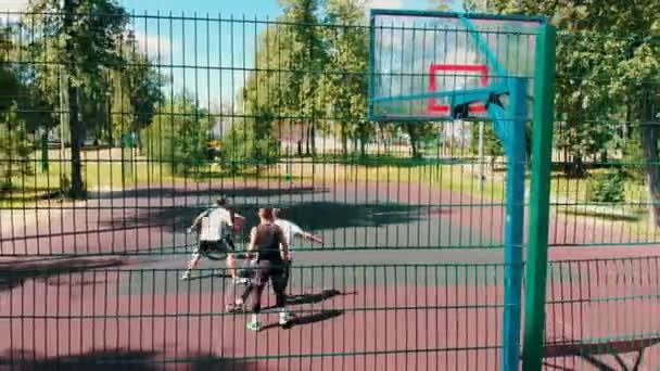 Cuatro hombres en forma jugando baloncesto en el campo de deporte en la calle en verano — Vídeos de Stock