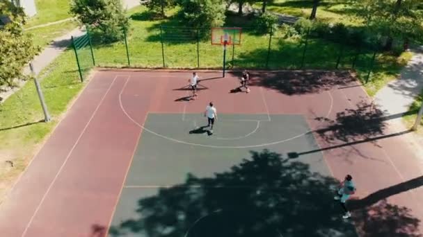 Cuatro amigos en forma jugando baloncesto en la cancha al aire libre — Vídeos de Stock