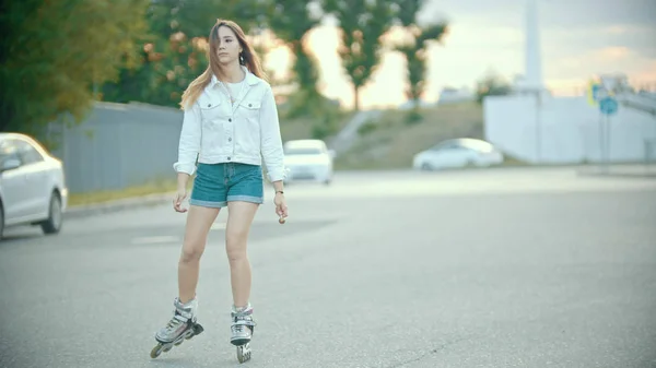 Una ragazza timida adolescente in pattini pattinaggio sulla strada — Foto Stock