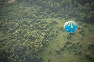 18-07-2019 Pereslavl-Zalessky, Rusya: Yeşil ağaç tarlasının üzerinde uçan mavi bir balon