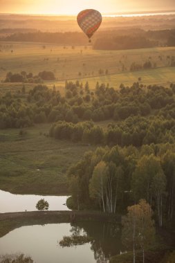Isı teknolojisi kullanarak alan ve rezervuarlar üzerinde uçan bir hava balonu - parlak gün batımı