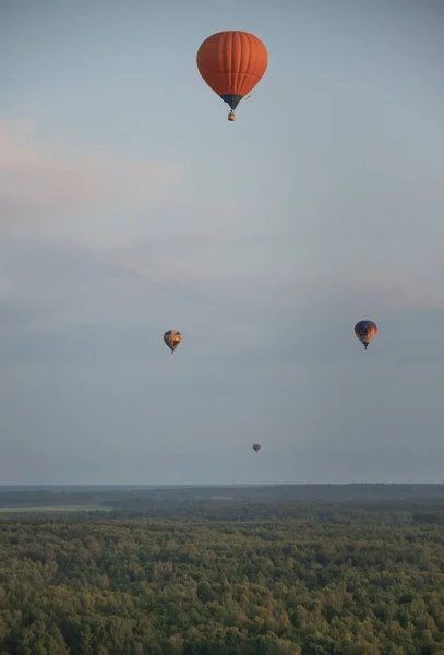 Quatro balões coloridos voando sobre o campo usando tecnologia de calor — Fotografia de Stock