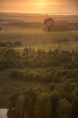 Ormanın üzerinde uçan bir hava balonu - parlak gün batımı