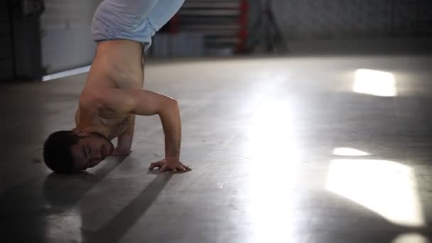 Homem pulando em suas mãos e levantando os pés, então ele se vira - Mostrando elementos de capoeira — Vídeo de Stock