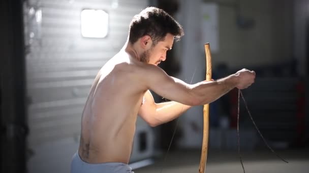 Młody atletyczny człowiek przygotowuje Narodowy brazylijski instrument berimbau — Wideo stockowe