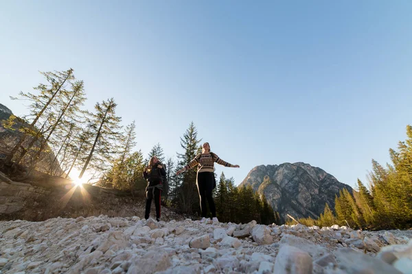 Δύο νεαρές γυναίκες τουρίστες περπατούν στο βράχο σε φόντο βουνά — Φωτογραφία Αρχείου