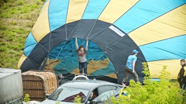 18-07-2019 Pereslavl-Zalessky, Oroszország: emberek előkészítése légballonok a repülő. egy nő, aki a szélét tartja a léggömb — Stock videók