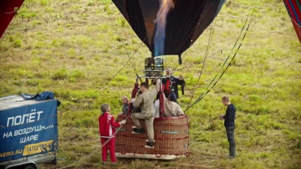 18-07-2019 Pereslavl-Zalessky, Oroszország: emberek előkészítése légballonok a repülő. izgatott ember ül a kosárban, és várja a repülés. — Stock videók