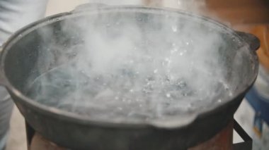 Büyük bir dökme demir Pan altındaki bazı su kaynatma