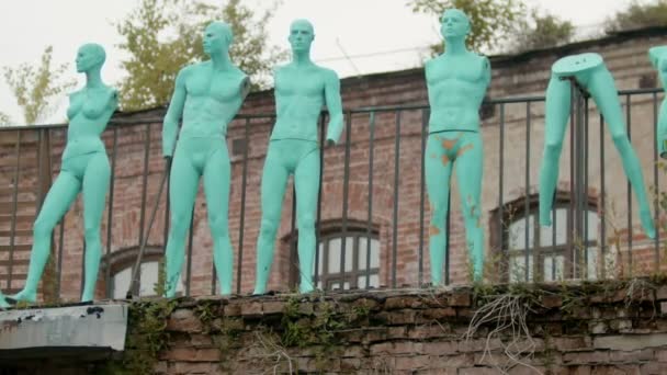 Maniquíes azules de personas de pie en el fondo de un antiguo edificio de ladrillo — Vídeo de stock