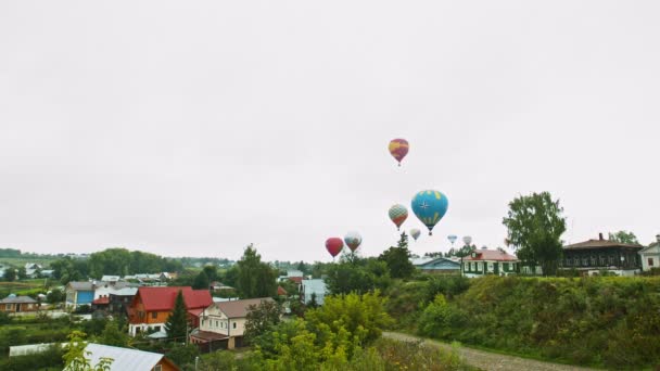 18-07-2019 Pereslavl-Zalessky, Rússia: diferentes balões de ar coloridos decolando sobre a aldeia — Vídeo de Stock