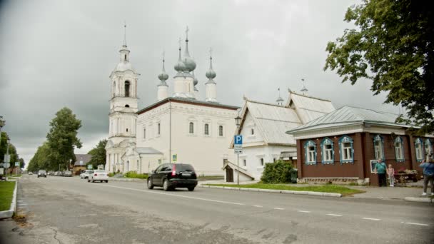 18-07-2019 Суздаль, Росія: велика християнська церква з блакитними куполами в селі-автомобілі, що проходять повз по дорозі — стокове відео