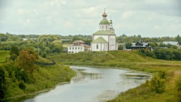 Christelijke kerk in het dorp-water kreek op de voorgrond-Suzdal, Rusland — Stockvideo