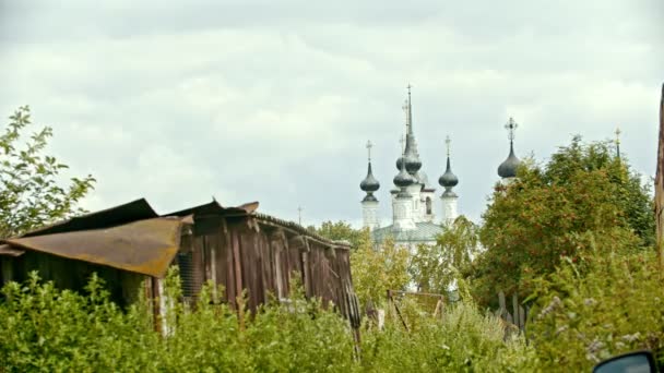 La vista a la aldea pequeña - la iglesia grande sobre el fondo - la casa vieja sobre el primer plano - Suzdal, Rusia — Vídeo de stock