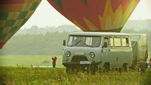 18-07-2019 Pereslavl-Zalessky, Rosja: samochód przybył na pole z ogromnymi kolorowe balony powietrza-zachód słońca — Wideo stockowe