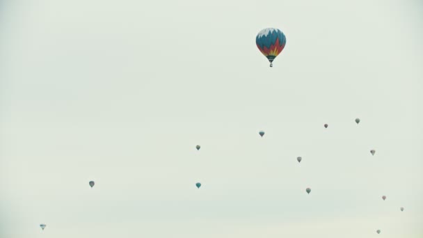 Grote lucht ballonnen vliegen in de witte hemel-een kleurrijke ballon op de voorgrond — Stockvideo