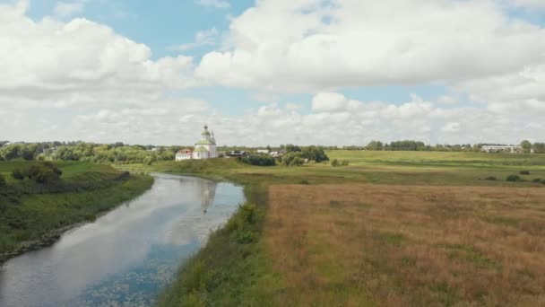 空旷的田野和河流上的一座孤独的教堂 - 俄罗斯苏兹达尔 — 图库视频影像