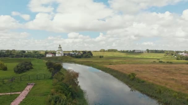 Gran iglesia cristiana blanca en el pueblo y un río - Suzdal, Rusia — Vídeo de stock
