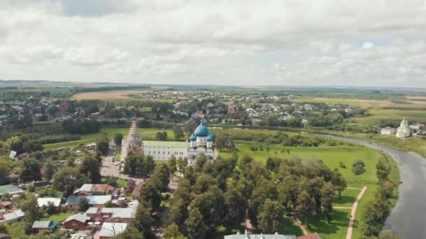 Wioska krajobrazu-architektura Kościoła i małe domy-zielone pole-Suzdal, Rosja — Wideo stockowe