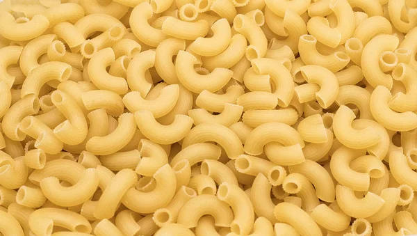 Pasta de cuernos largos en cantidades - textura de macarrones — Foto de Stock