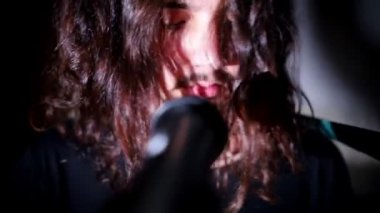 Uzun saçlı Genç bir adam onun performansında bir şarkı şarkı bitirdi