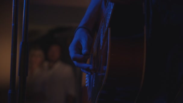 Bir adam bir mızrap ile akustik gitar oynuyor-Karanlık kulüp bir performans — Stok video