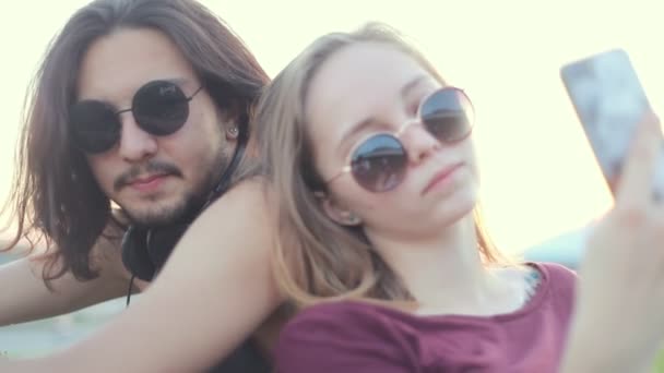 Pareja joven en gafas redondas tomando una selfie al aire libre — Vídeo de stock