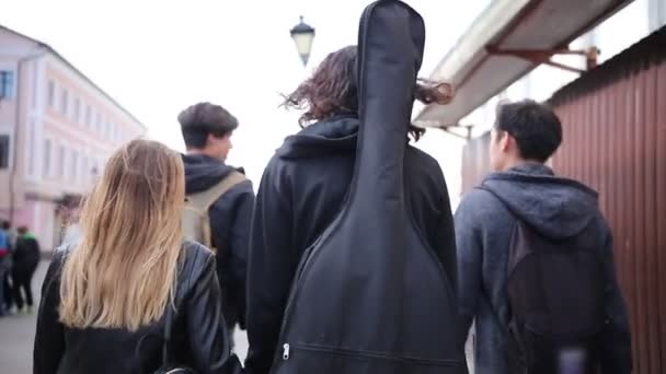 Молоді друзі ходять по вулиці під час похмурої погоди — стокове відео