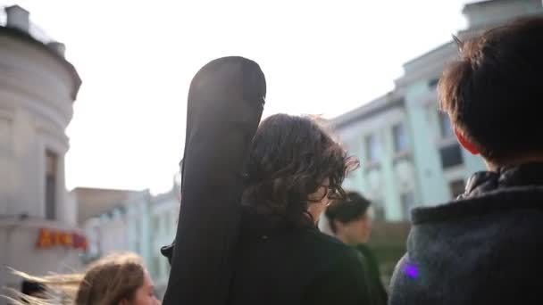 Jóvenes amigos caminando por la calle abarrotada — Vídeos de Stock