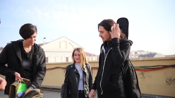 Unga vänner som står på gatan-en man som söker efter flaskan i sin ryggsäck — Stockvideo