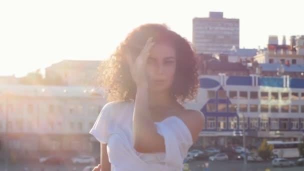 Attractive mulatto young woman with curly hair dancing and flirting with a viewer - looking in the camera — Stock Video