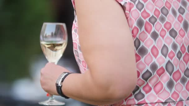 Eine Frau in rosa Kleid mit einem Glas Trinken — Stockvideo