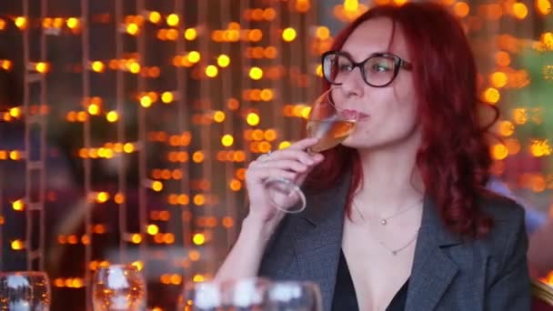 En kvinna som sitter vid bordet i restaurang och dricker champagne — Stockvideo