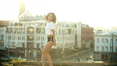 Çatıda çekici dans eden genç bir kadın - gün batımı