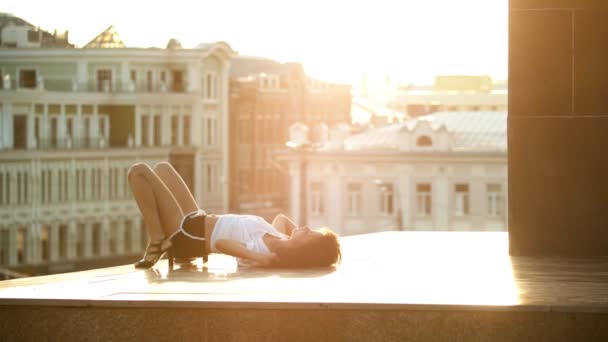 Una giovane donna attraente con i capelli ricci che esegue elementi di danza a terra - sfondo di edifici - tramonto — Video Stock