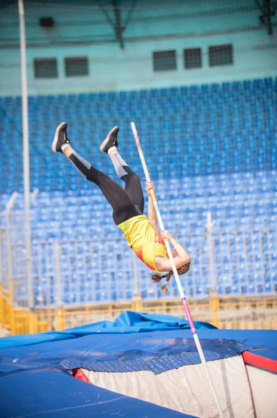 Klenba na pólu-ženský skokan, který padá po skoku na stadionu — Stock fotografie