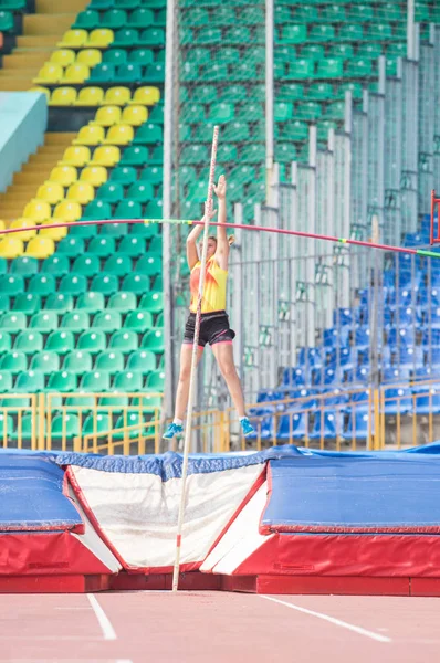 Stabhochsprung - junge Frau springt im Stadion über die Stange — Stockfoto