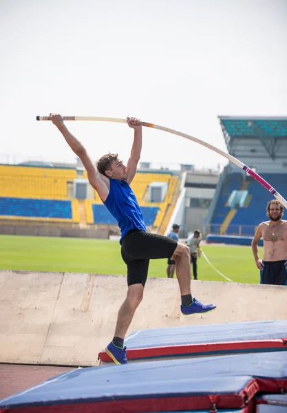 Stabhochsprung - ein junger, athletischer Mann liegt auf der Stange am Boden — Stockfoto