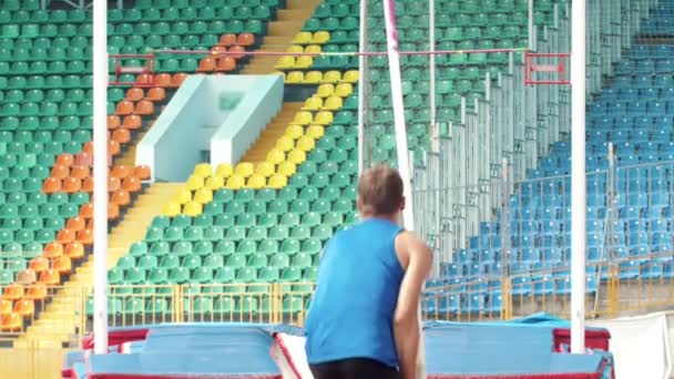 Sırıkla atlama - genç bir adam bir sırık tutarak kadar çalışır hazırlar — Stok video