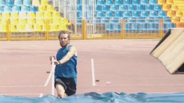 Sırıkla atlama - esnek bir direk kullanarak bar üzerinden atlama sakallı atletik bir adam
