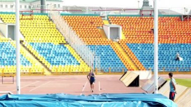 Pole vault - bir atletik adam kadar çalışan ve kutup üzerinde yere karşı dinlenmek
