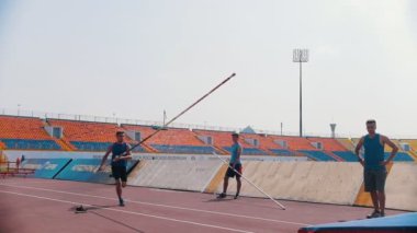 Kazan, Rusya 26-07-2019: bir adam kadar çalışan ve bar üzerinden atlamak için bir direğe yaslanır - sırıkla atlama eğitimi