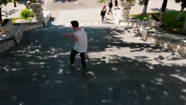 Fiatal stílusos férfi fehér inget táncolt a lépcsőn, és séta a földszinten — Stock videók