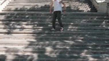 Kazan, Rusya 03-07-2019: Beyaz gömlekli genç, merdivenlerde dans eden ve alt katta yürüyen genç şık adam