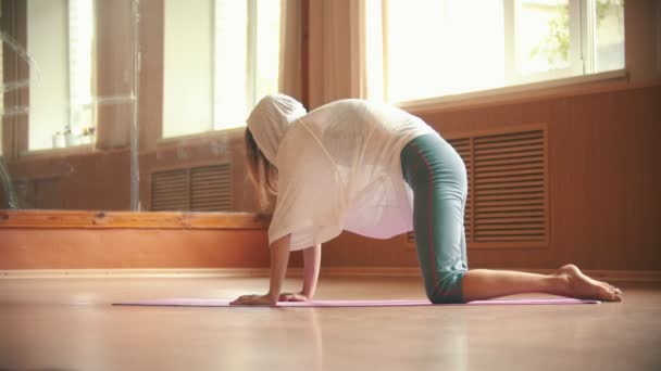 Jovem mulher bonita se exercitando no tapete de ioga - realizando um exercício para o lombo e coluna — Vídeo de Stock