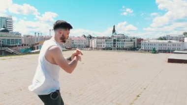 Şehir merkezinin arka planda çatıda dans genç yakışıklı dövmeli adam